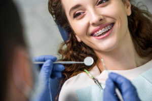 close up of cheerful woman in braces during examination of teeth
