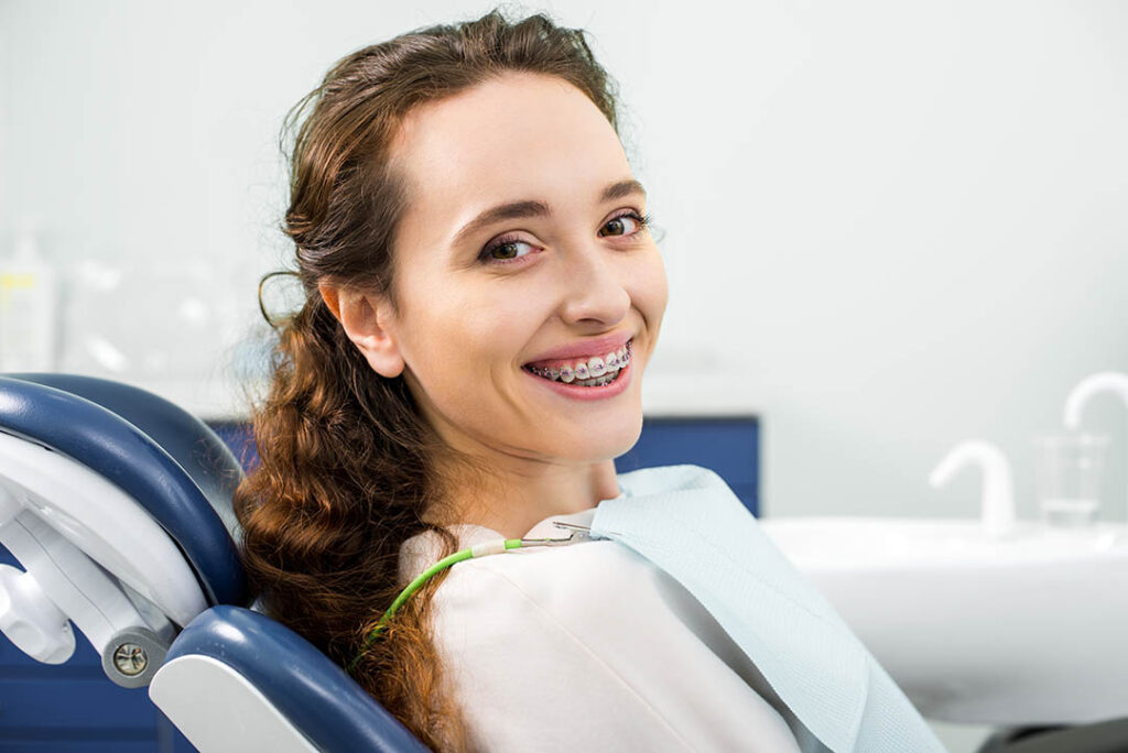 happy woman in braces smiling during orthodontist examination