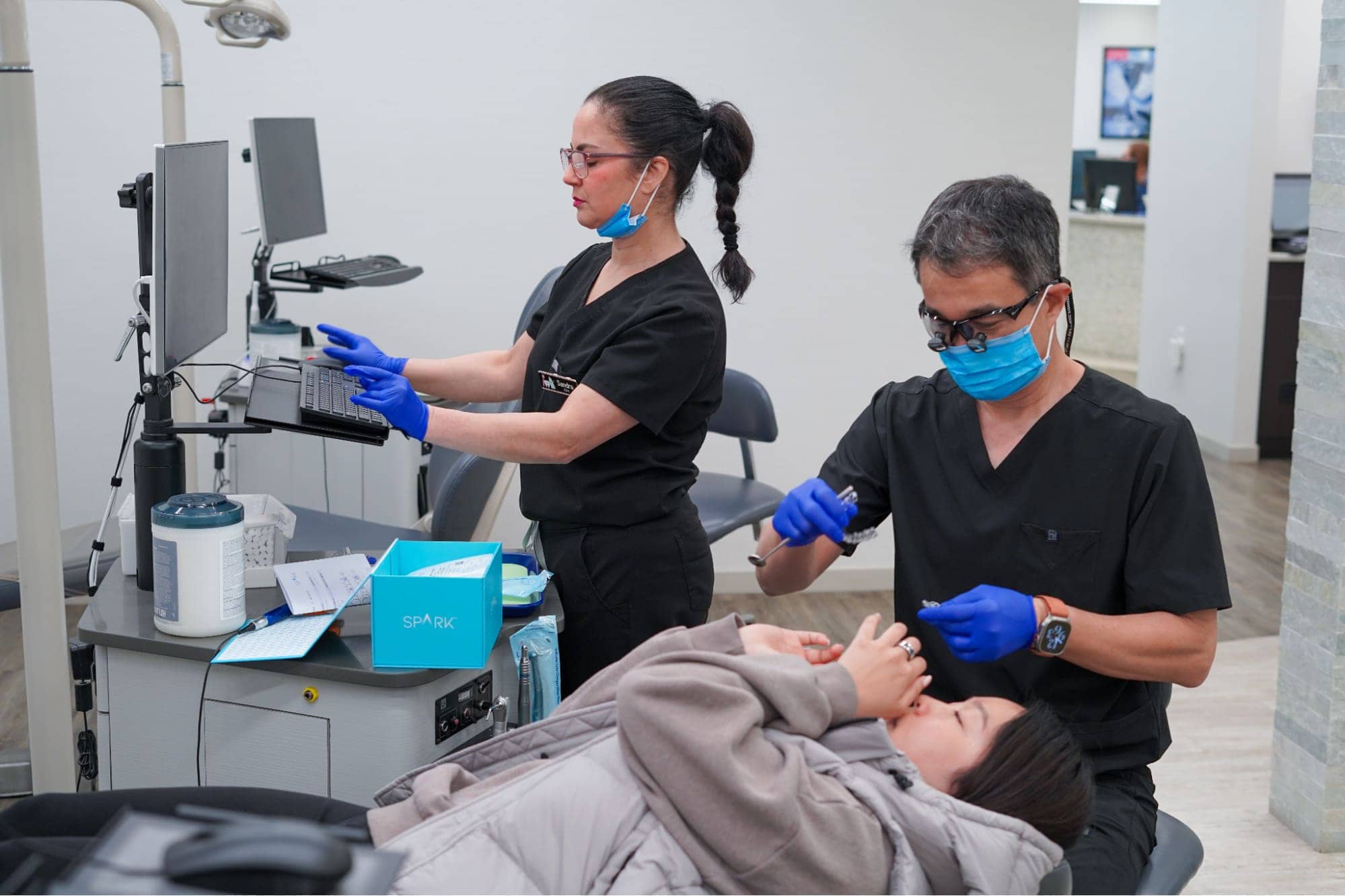 Dr. Chung and an assistant providing Spark clear aligner treatment to a patient.