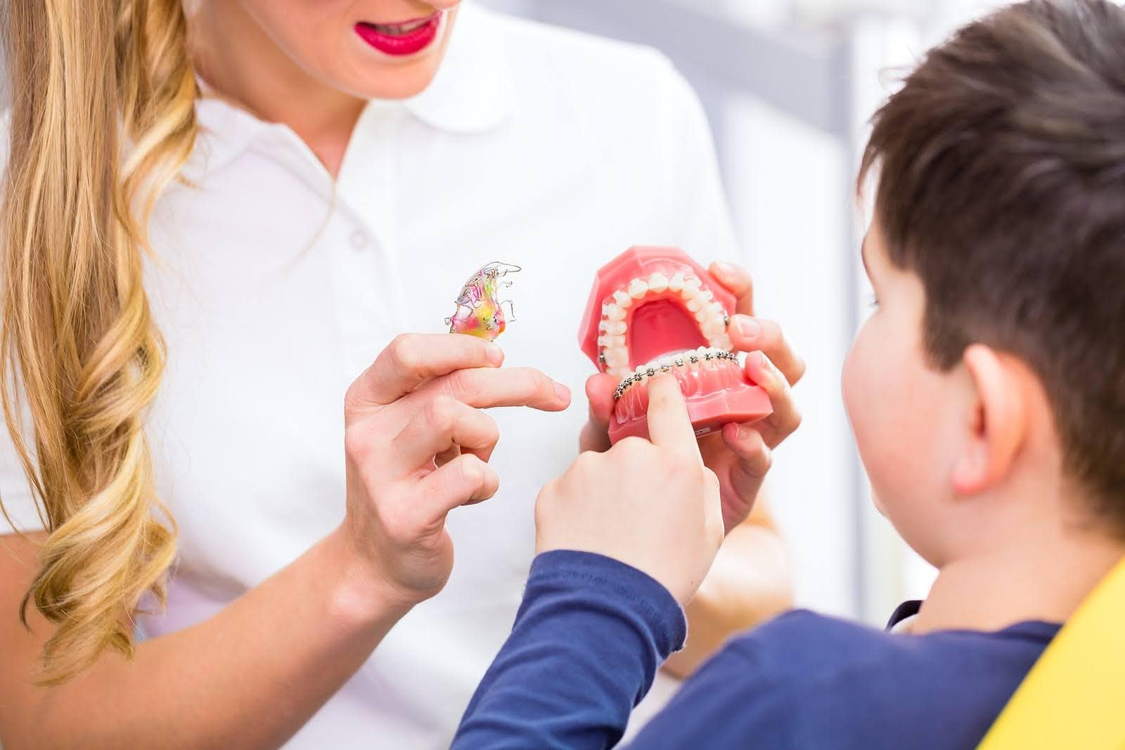 Female Orthodontist Explaining Treatment Plan To Young Patient